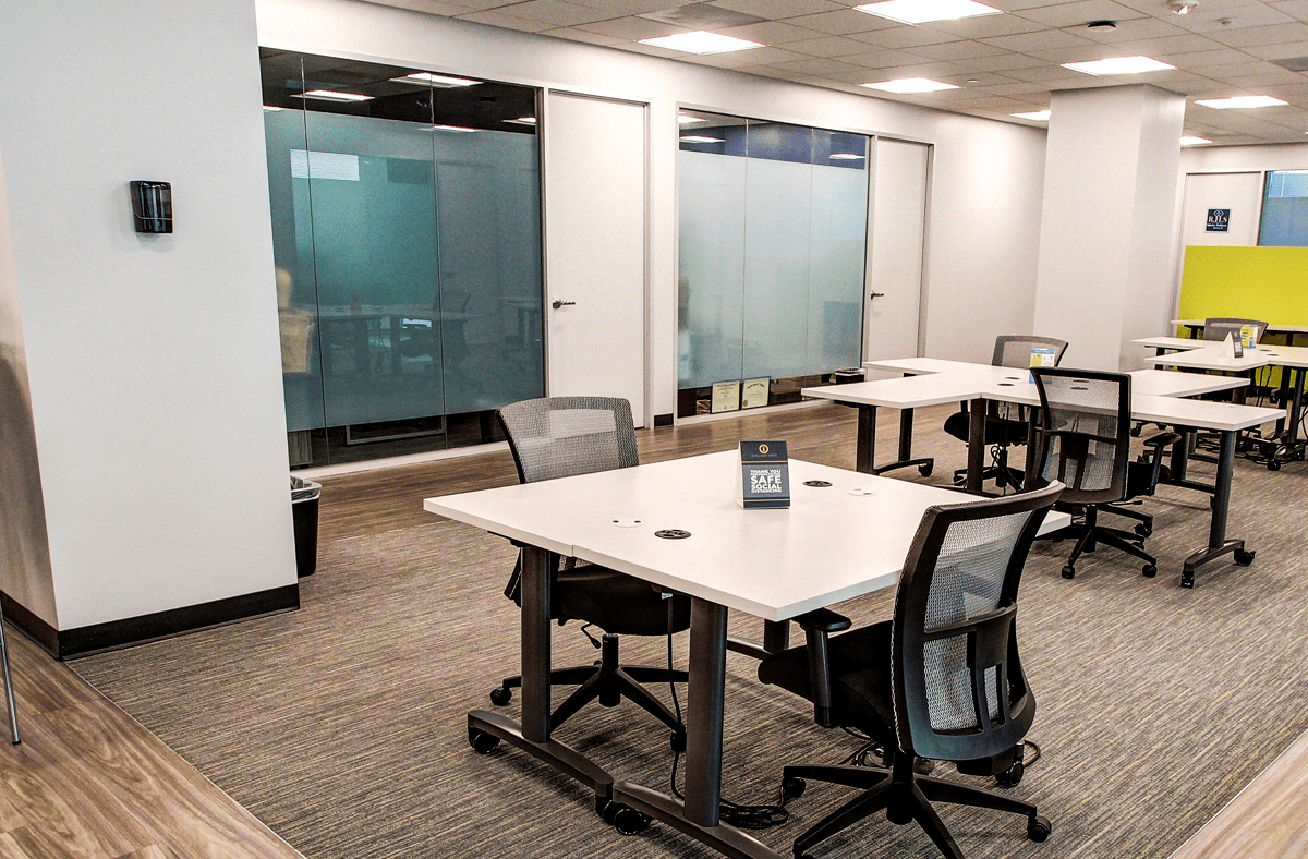 Modern office workspace with desks, chairs, and glass partitions, ideal for intelligent office franchising and professional business environments.
